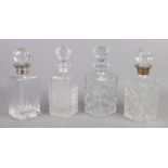 Four glass/crystal decanters, including two silver collared examples.