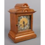 A carved oak eight day mantel clock, chiming on a coiled gong. With pendulum and key. Height 32cm.