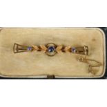 A cased 9ct gold bar brooch set with three sapphires. 2.43g.