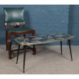 A carved oak and vinyl chair, together with a glass topped coffee table.