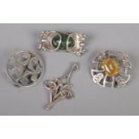Three Scottish style silver brooches and a silver pendant.