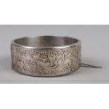 A silver bangle with chased decoration. Assayed Chester 1953 by Joseph Smith & Sons Ltd. 42g.