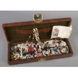 A jewellery box with contents of costume jewellery. Includes Snoopy watch head, rings, necklaces