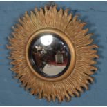 A gilt framed sunburst convex mirror. Cracks to the frame.