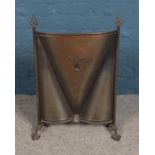 A copper fire screen with Art Deco style motif.