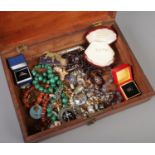 A 19th century mahogany box with contents of costume jewellery. Includes glass beads, rings,