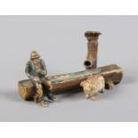 An Austrian cold painted bronze miniature of a trough, pump, farmer and pig. Stamped '3917', bearing