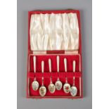 A cased set of six silver and enamel spoons featuring floral designs including roses and pansies.