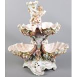 A large Meissen style ceramic centrepiece formed as shells. With cherubs and flowers. (44cm)
