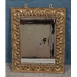 A brass framed bevel edged mirror mirror, with shell decoration and rope twist border. Height: 55cm,