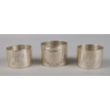 A trio of silver napkin rings, including one matching pair (Assayed Birmingham 1984). Single ring