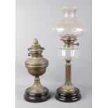 Two oil lamps, previously converted to electric. One with translucent pink shade. Damage to mount of