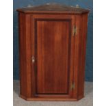 A George III oak corner wall mounted corner cupboard. 90cm.