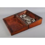 A Nineteenth century mahogany writing slope containing silver watch cases, charms, and silver and