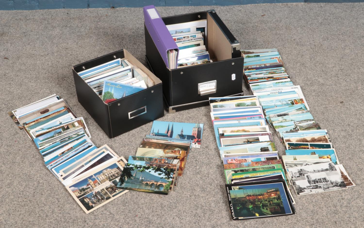 Two boxes containing a large quantity of postcards, with one box unused.