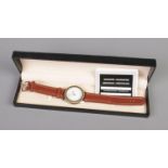 A men's M watch with brown leather strap. Includes certificate of authenticity and box.