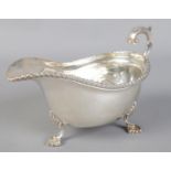A silver sauceboat with scrolled handle. Assayed Birmingham 1928 by Mappin & Webb. 279g.