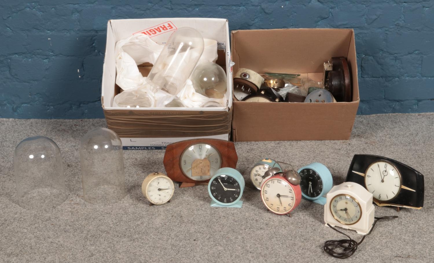 Two boxes of clocks and glass domes. Including alarm clock examples, etc.