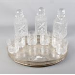 A decorative silverplate tray with decanters and glass set.