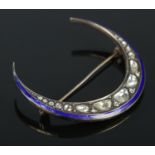 A vintage white metal and enamel crescent formed brooch set with nineteen rough cut diamonds.