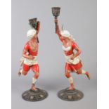 A pair of cold painted spelter figural candlesticks, modelled as Turks holding torches. 39cm. One in