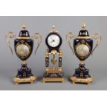 A gilt metal and ceramic three piece clock garniture, with Roman Numeral face and central piece