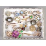 A tray of costume brooches. Including Stratton equestrian brooch, coloured paste examples, etc.