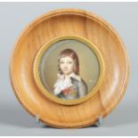 A circular framed portrait miniature depicting a child. 5.5cm diameter.