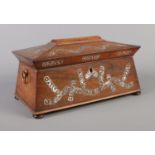 A Victorian tea caddy of sarcophagus form, having mother of pearl inlay and brass loop handles.