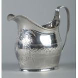 A George III silver cream jug with engraved decoration. Assayed London 1803 by Samuel & Edward