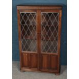 A Priory style oak bookcase with lead glazed glass panel doors. (132cm x 81cm)