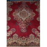 A large red ground carpet with floral decoration. (396cm x 300cm)