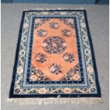 A Chinese style blue ground wool rug, with geometric design and frayed edges with central