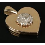 An 18ct Gold heart-shaped locket, with diamond cluster to the front. Total weight: 14.49g.