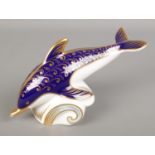 A Royal Crown Derby paperweight formed as a dolphin.