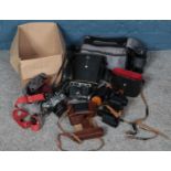 A box of cameras and binoculars. Including Agfa Isolette bellows camera, Canon AV-1 camera, etc.