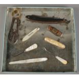 A tray of collectables. Includes mother of pearl page turner with folding knife, cut throat razor,