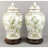 A pair of mid 20th century Chinese lidded baluster vases, raised on carved hardwood stands. Bears