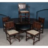 An Ercol X frame extending dining table with four matching dining chairs and one carver.