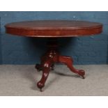A mahogany circular tilt-top table, with central pillar supported by three cabriole feet, raised