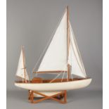 A multi-sail model pond yacht on stand. 77cm tall (on stand).