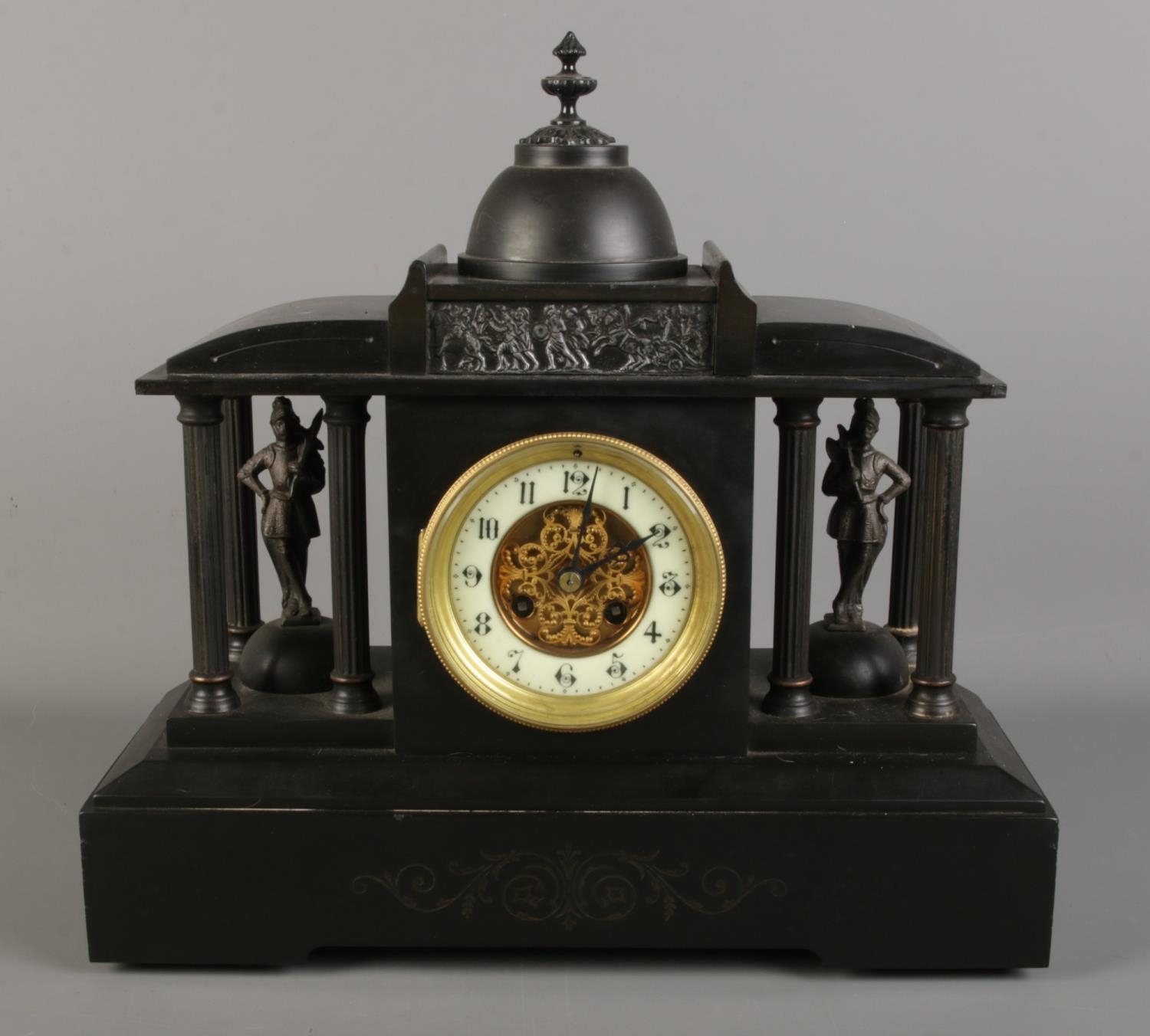 A black slate mantel clock, formed as a Roman colosseum, with Corinthian pillars surrounding soldier