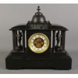 A black slate mantel clock, formed as a Roman colosseum, with Corinthian pillars surrounding soldier