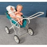 A vintage pram along with two dolls.