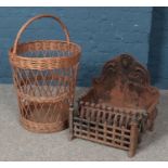 A Cast iron fire grate along with a wicker log basket.