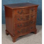 A small mahogany serpentine four drawer chest.