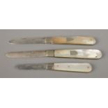 Three silver bladed and mother of pearl fruit knives, two with blank crests to the body. All assayed