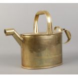 A brass watering can, with hinged top. 26cm high.