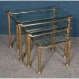 A set of three glass topped nesting tables with brass frames. Largest table dimensions 64cm x 40cm x