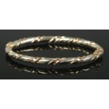 A 9ct Gold bangle with twisted decoration and hinged clasp. Total weight: 9.95g